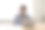 微笑的商人戴着耳机坐在办公桌前，手里拿着笔记本电脑图片下载