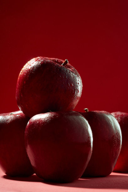 一组红苹果堆在红色的背景上图片下载