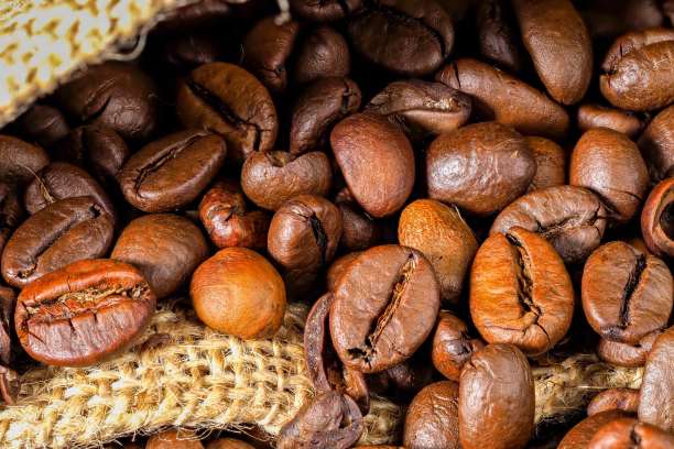 烘培咖啡豆在粗糙的布近距离微距照片。咖啡馆的概念，咖啡馆，舒适的家，香气和味道。图片下载