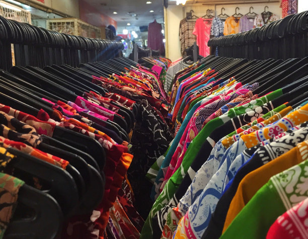 服装店里，五颜六色的衣服整齐地挂在黑色的衣架上。图片下载