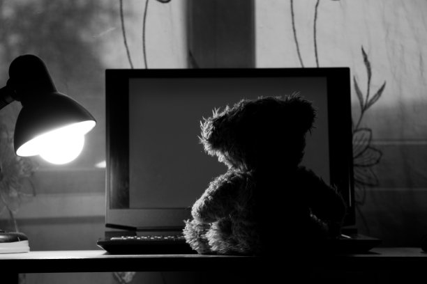 给孩子的泰迪熊坐在桌子上拿着笔记本电脑，晚上在卧室里拿着台灯，拿着窗户，孤独，笔记本电脑图片下载