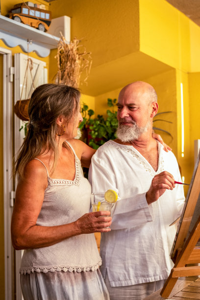 一对自信、快乐的老年夫妇在客厅里画画，享受着他们的闲暇时光和生活图片下载