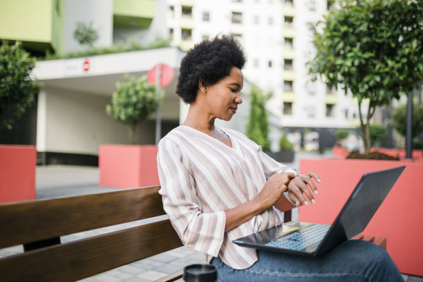 成功的商业女性看着她的手表图片下载