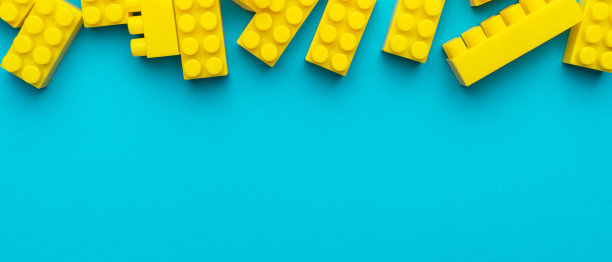 黄色塑料积木在蓝绿色背景与复制空间图片下载