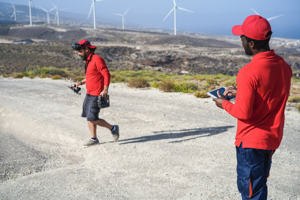 多种族工程师在一架风车农场无人机上工作——关注非洲人拿着平板电脑的手图片下载