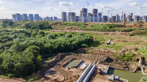 河流排水渠施工鸟瞰图。建筑工程排水沟以防止城市洪水泛滥。把水排到河里去。图片下载