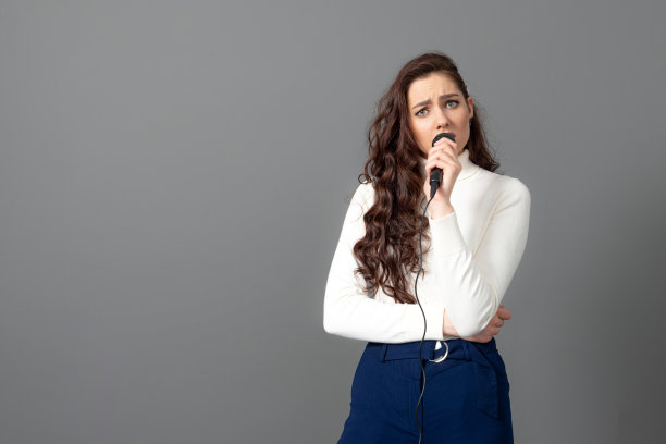 有魅力的女性演讲者在演讲期间，拿着麦克风，做一些手势图片下载