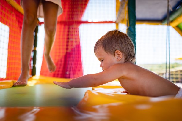 夏天，哥哥和姐姐在游戏室里玩，在蹦床上跳图片下载