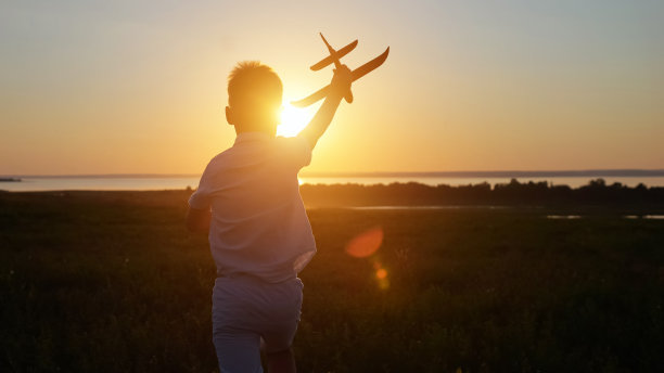 少年在草地上奔跑，直到日落发射飞机图片下载