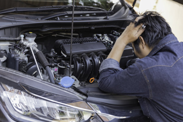 有个人在检查车。汽车出了故障，在旅途中汽车坏了。图片下载