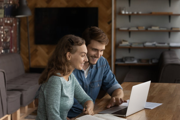 两个快乐的商务专业人士在现代办公室使用笔记本电脑图片下载