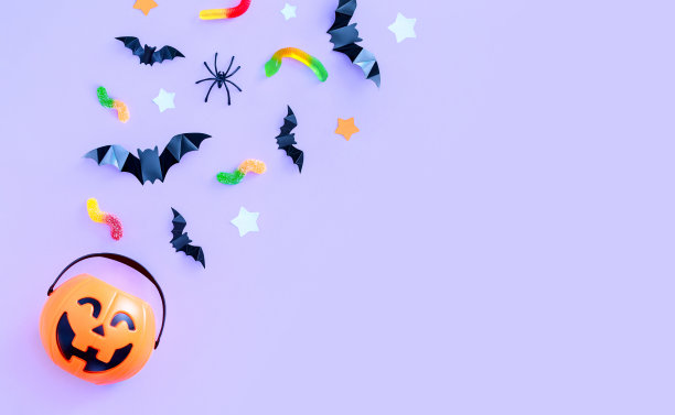 作文的节日主题万圣节桶南瓜糖果蝙蝠蜘蛛在一个紫色的背景与文字的地方图片下载