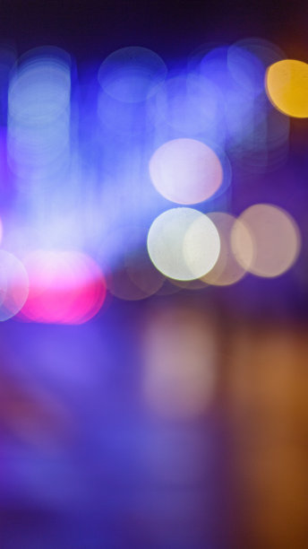 在马德里明亮的街道上，圣诞灯和汽车前灯的散焦背景图片下载