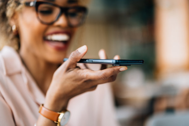 坐在咖啡馆里录制语音信息的美女肖像图片下载