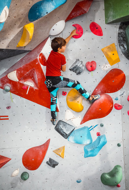 小男孩在攀爬室内的攀岩墙图片下载