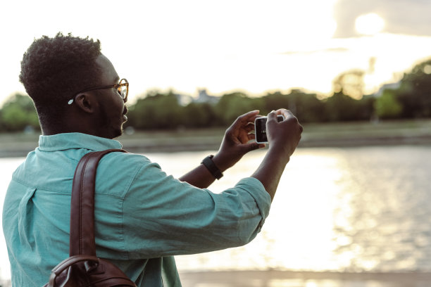 一位非洲裔美国年轻人正在拍摄这条河的照片图片下载