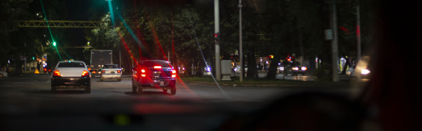 在车内的雾灯照射下，从乘客舱看夜间道路，路面潮湿，玻璃肮脏，能见度很低。前后背景模糊与散景效果图片下载