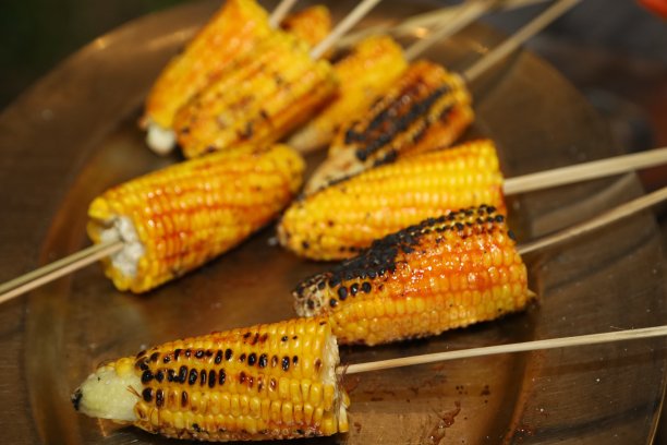 雨季，印度瓦拉纳西的街道上正在出售美味的玉米。出售烤玉米。商店里挂着出售的玉米。烤玉米。图片下载