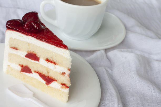 早上在白桌布上放草莓芝士蛋糕和一杯咖啡。图片下载
