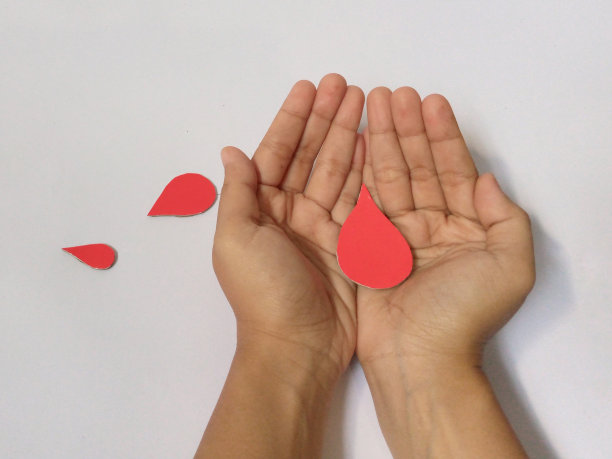 献血观念，输血观念。女人的手上握着一滴血就白了图片下载