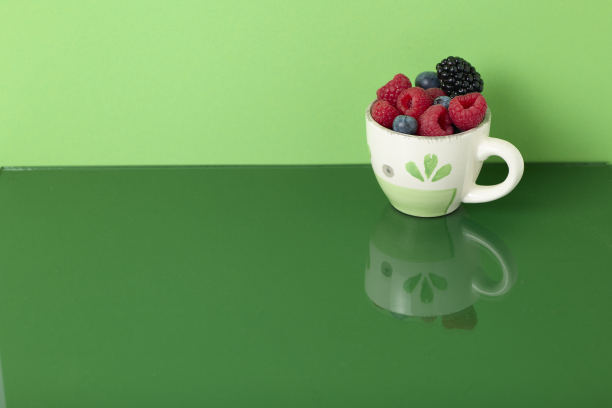 杯，红色水果在绿色的背景图片下载