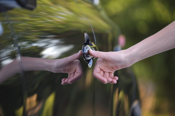 触摸ID指纹扫描技术，驾驶员手打开汽车前门的特写。车辆安全概念图片下载