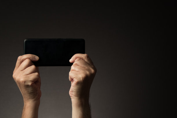 双手横握智能手机，后视图图片下载