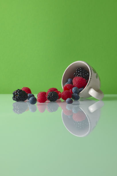 杯，红色水果在绿色的背景图片下载