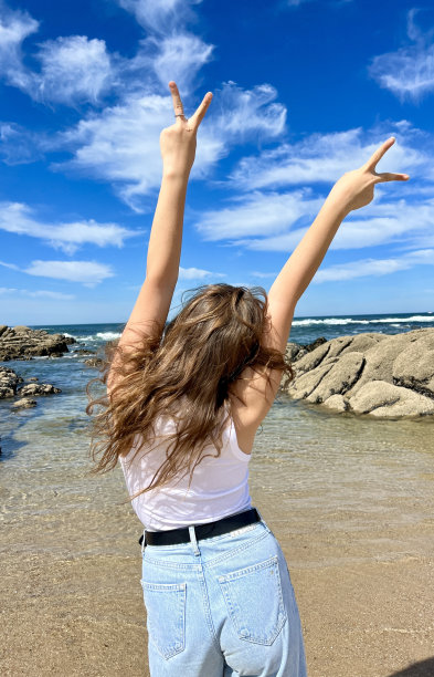 一个开朗的十几岁的女孩穿着漂亮的衣服，站在她的对面，她举起手，可以给旅行社打广告去葡萄牙旅游图片下载