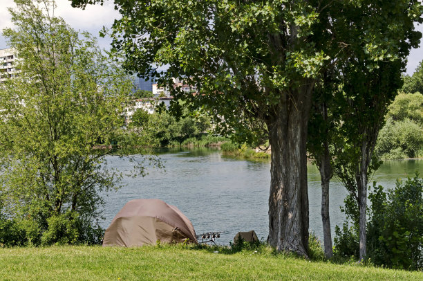 早春时节，绿树成荫，绿草如茵，帐篷搭在德鲁伊巴居民区的湖边图片下载