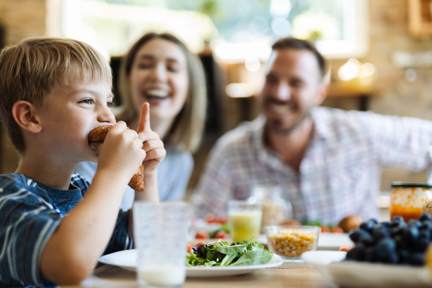 小男孩早餐吃牛角面包图片下载