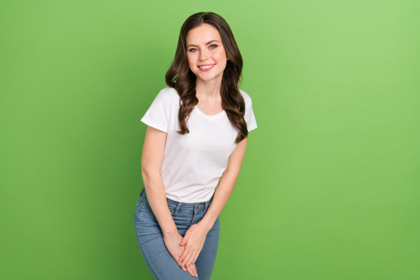梦幻可爱的年轻女士穿白色t恤微笑孤立的绿色背景的照片图片下载