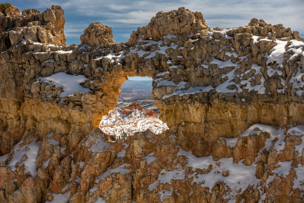 透过一堵被雪覆盖的墙的拱形窗户可以看到胡芦巴图片下载