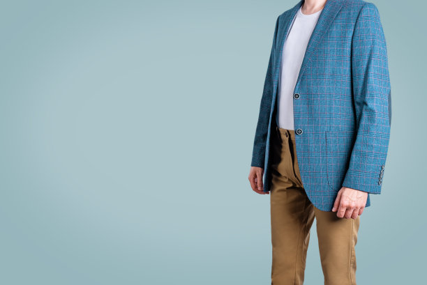 穿着蓝色夹克，米色裤子，蓝色背景的男人图片下载