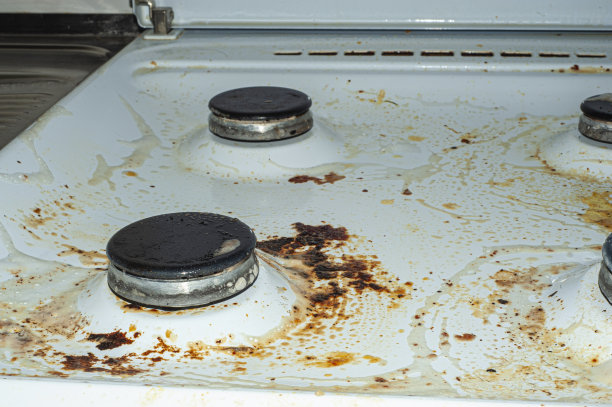 用剩菜弄脏炉子。不干净的燃气厨房灶台上有油腻的斑点，旧的脂肪渍，油炸的斑点和油飞溅图片下载