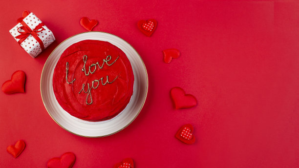 有奶油芝士糖霜的红色蛋糕。豪华的蛋糕，红色背景上有金色装饰图片下载