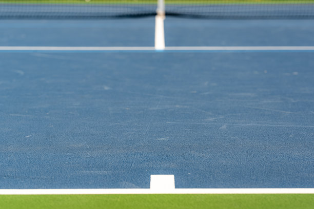 一个新的蓝色网球场的基线的特写照片。图片下载