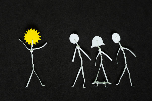 传播积极的观念，做一缕阳光或光给别人。以太阳为头的男子简笔画在黑黑的背景中鼓舞他人。图片下载