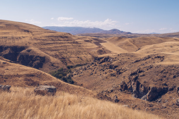 背景是如画的亚美尼亚秋景。亚美尼亚山区的田野和草地。神奇的蓝天和白云。库存图片图片下载