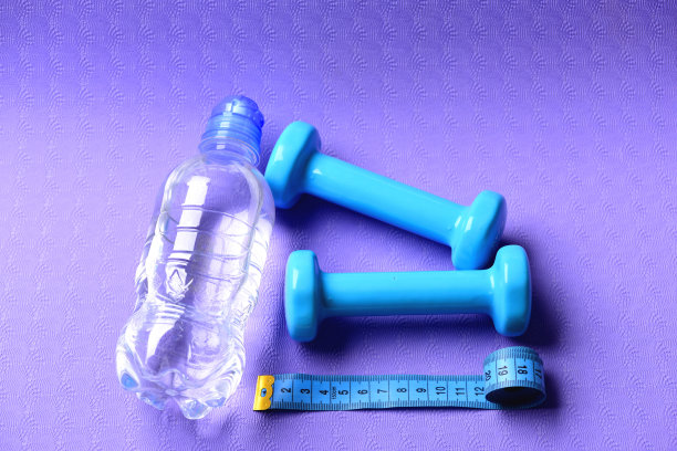 杠铃旁边有卷尺和水瓶图片下载