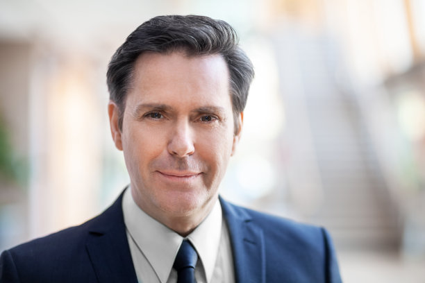 成熟商人的头像站在办公室大堂微笑图片下载