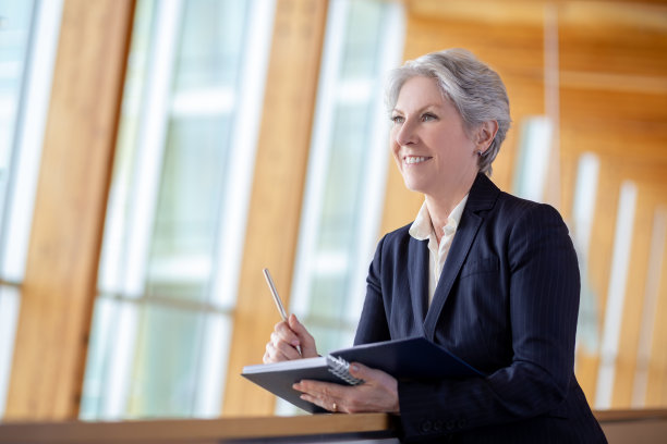 微笑的高级高加索女商人的肖像靠在栏杆在办公室阳台与日计划不看图片下载