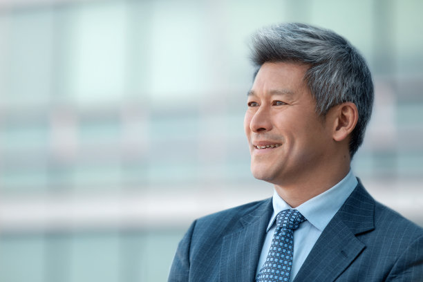 中国成熟商人的头像，在户外，看着别处微笑图片下载