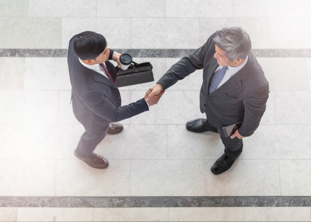 太平洋岛民和中国商人在办公室大堂会面握手的全景图片下载