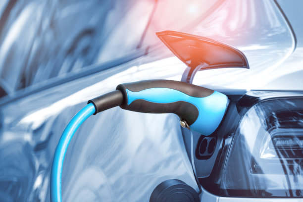 电动汽车用电源线连接到充电站图片下载