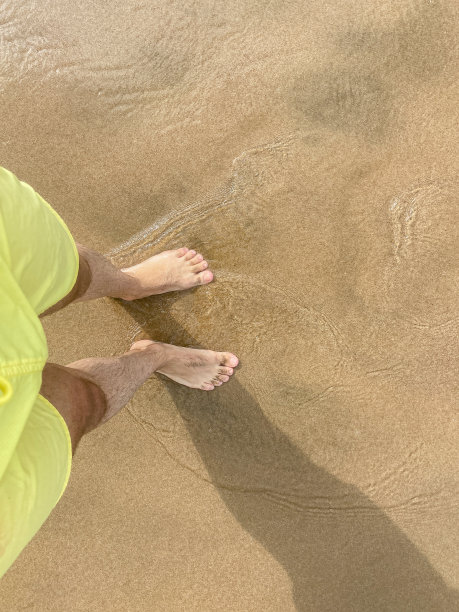 脚踩在沙滩上带着波浪图片下载