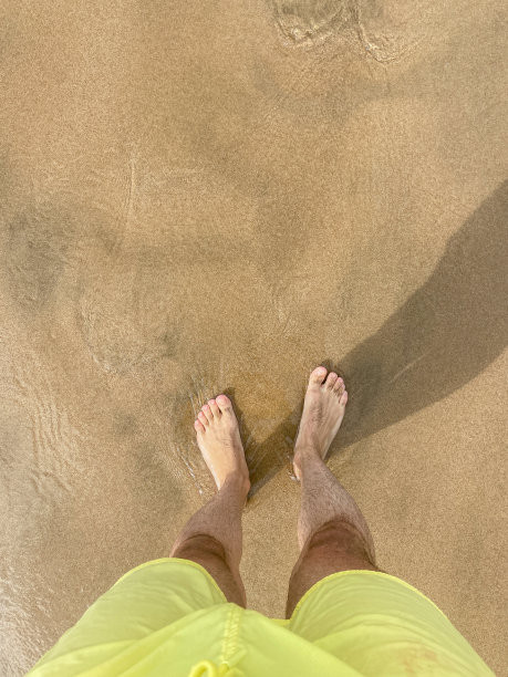 雄性的脚踩在沙滩上图片下载