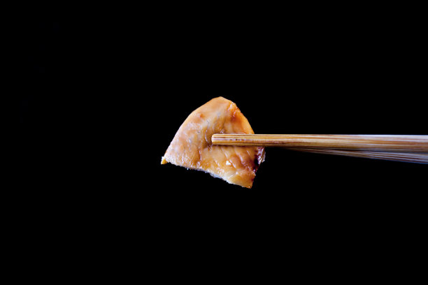 用木筷子夹住的一块煮熟的鱼图片下载