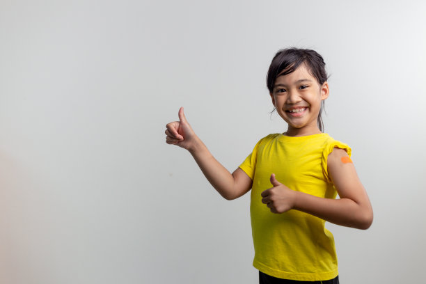 COVID 19儿童疫苗概念。工作室拍摄了一个可爱的亚洲女孩在接种第一剂疫苗后的肖像。免疫，安全，可用，回到学校。图片下载