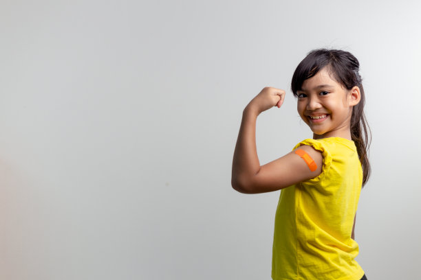 COVID 19儿童疫苗概念。工作室拍摄了一个可爱的亚洲女孩在接种第一剂疫苗后的肖像。免疫，安全，可用，回到学校。图片下载